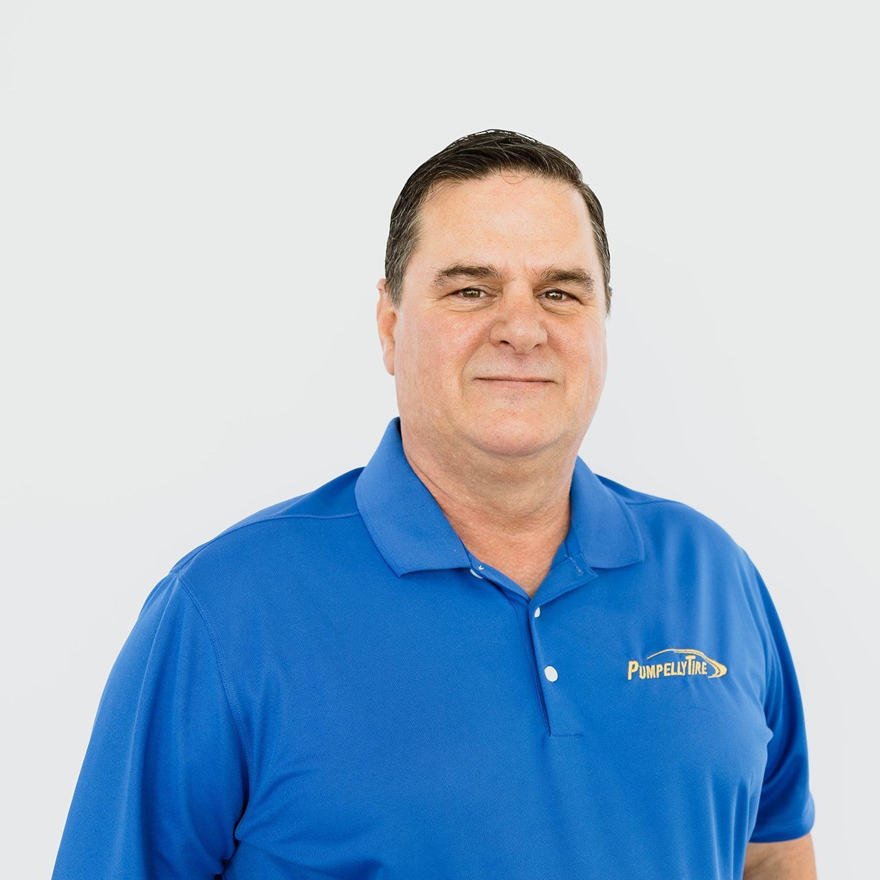 A person with short dark hair wearing a blue collared shirt, centered against a plain white background.