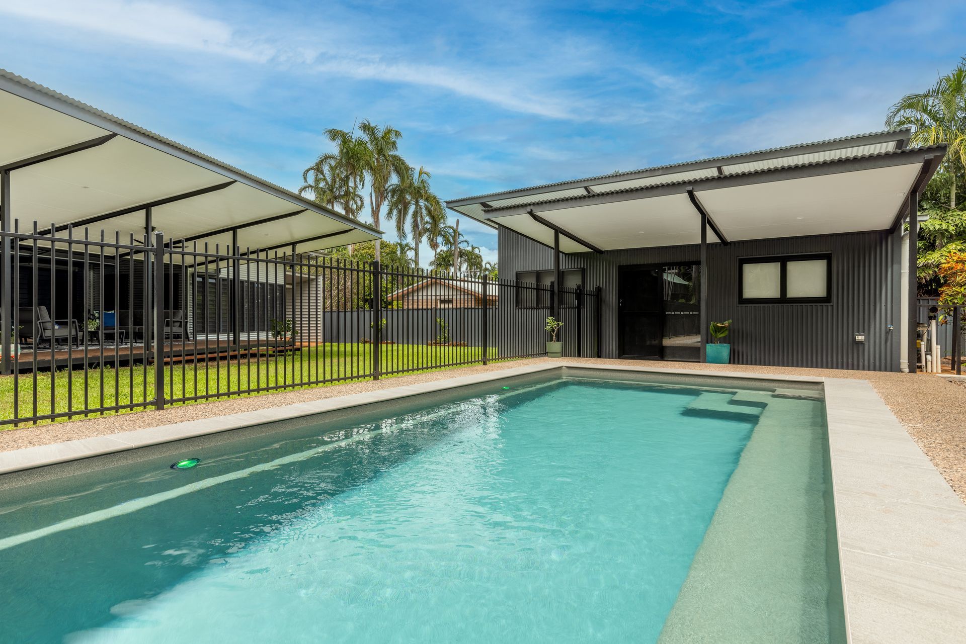 There Is a Large Swimming Pool in The Backyard of A House — Pooltech NT In Alawa, NT