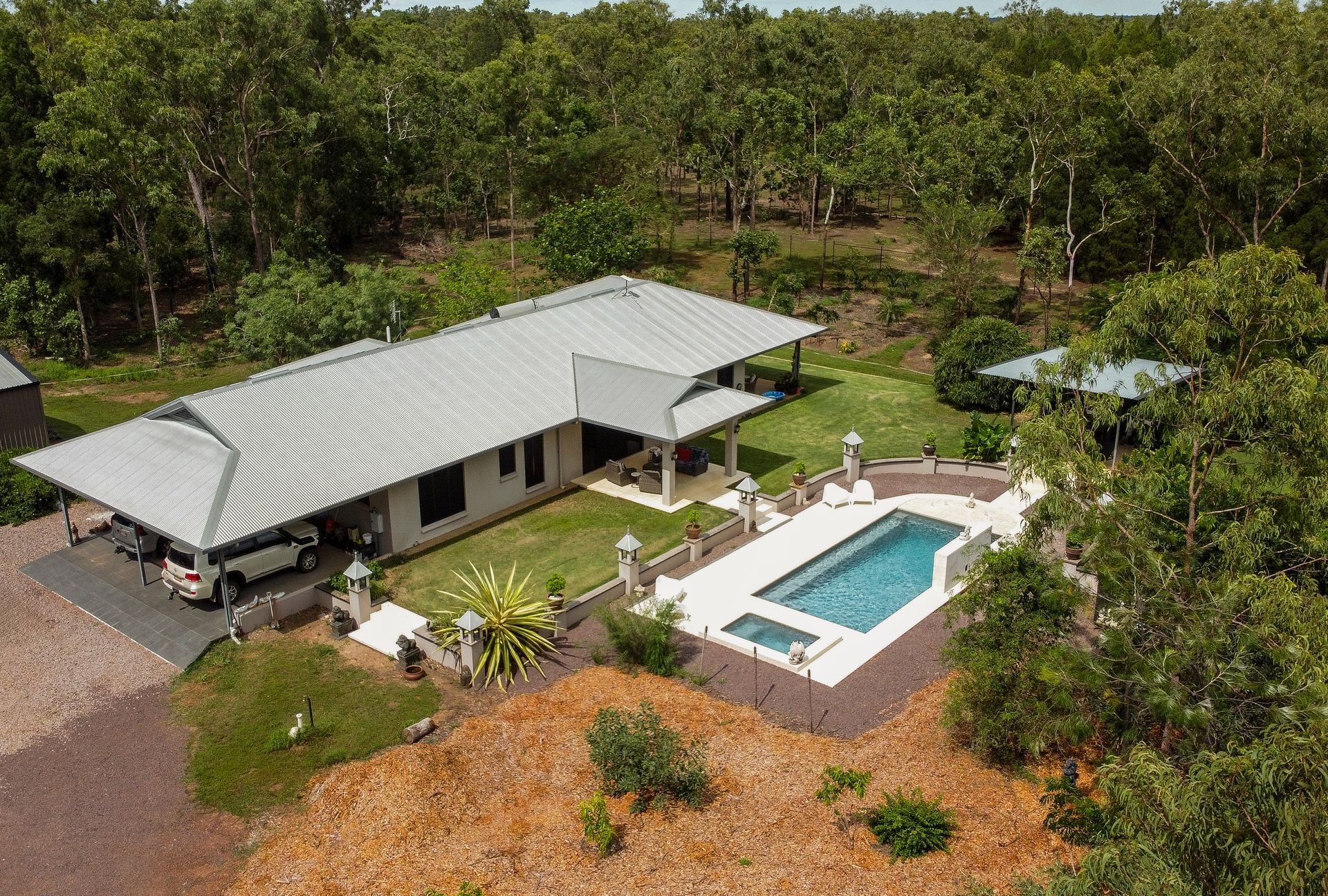 An Aerial View of A House with A Large Swimming Pool Surrounded by Trees — Pooltech NT In Alawa, NT