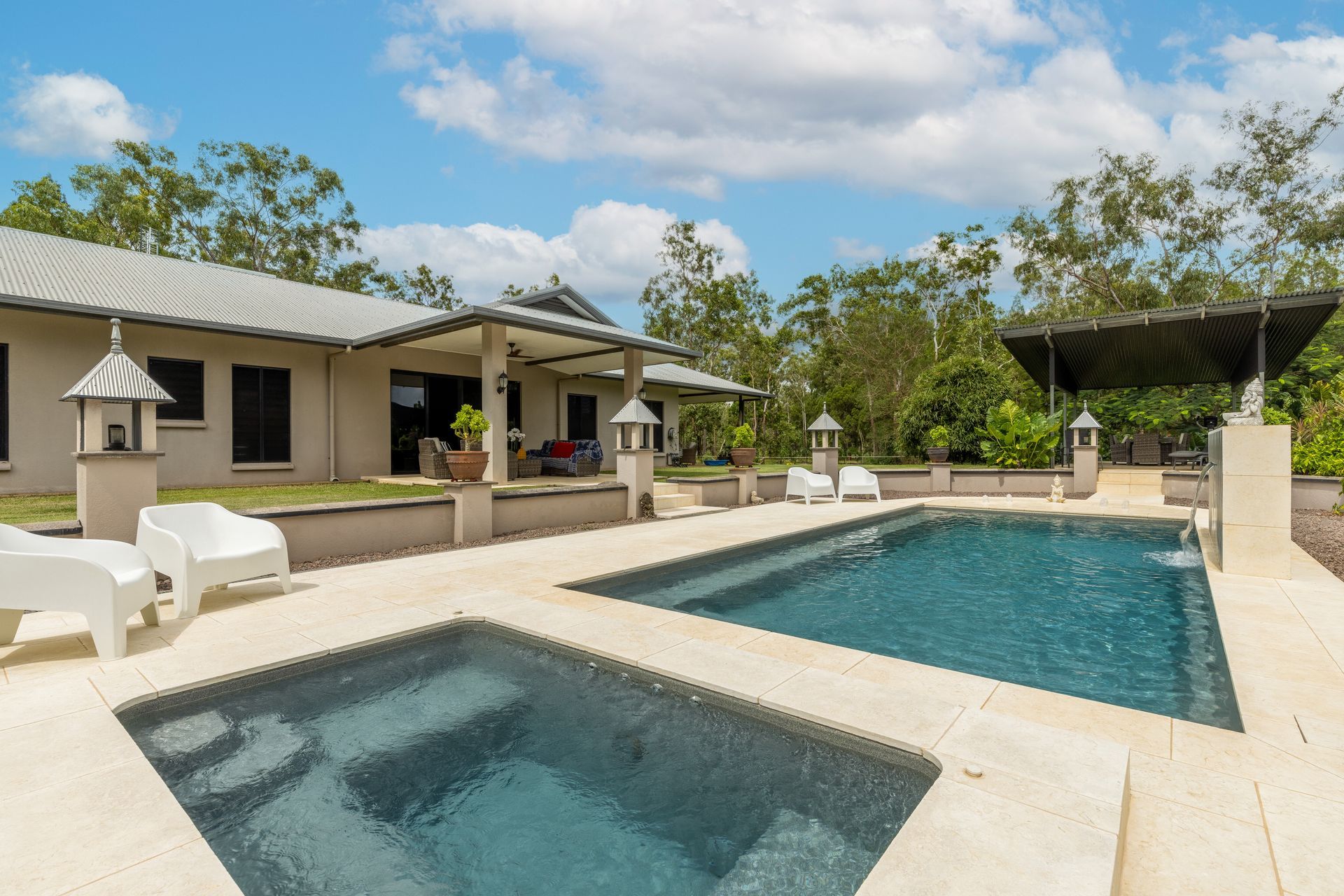 A Large Swimming Pool with A Hot Tub in Front of A House — Pooltech NT In Alawa, NT