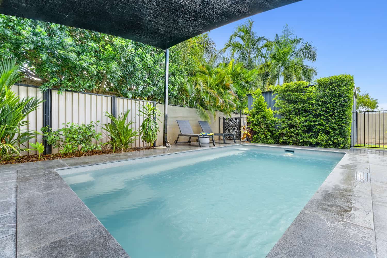 A Large Swimming Pool is Surrounded by Chairs and Trees — Pooltech NT In Alawa, NT