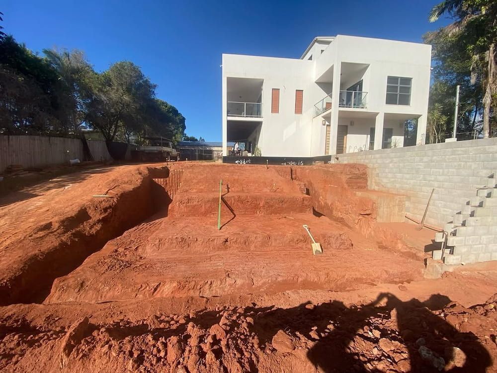 Construction Site With House in Background — BC Earthmoving & Civil Construction in East Barron QLD
