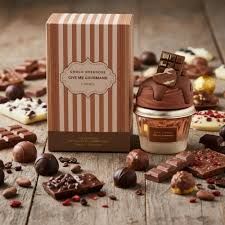 Chocoladelekkernijen in een geschenkdoos op een houten tafel.