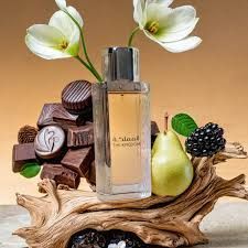 Parfumflesje met peer, bramen, chocolaatjes en witte bloemen op een houten standaard.