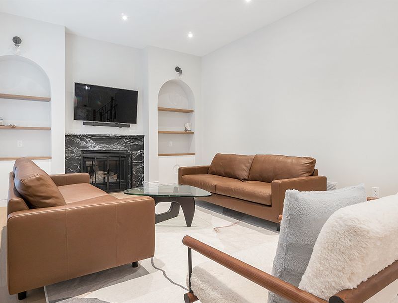 Living room with brown leather sofas, fireplace, and neutral-toned walls.