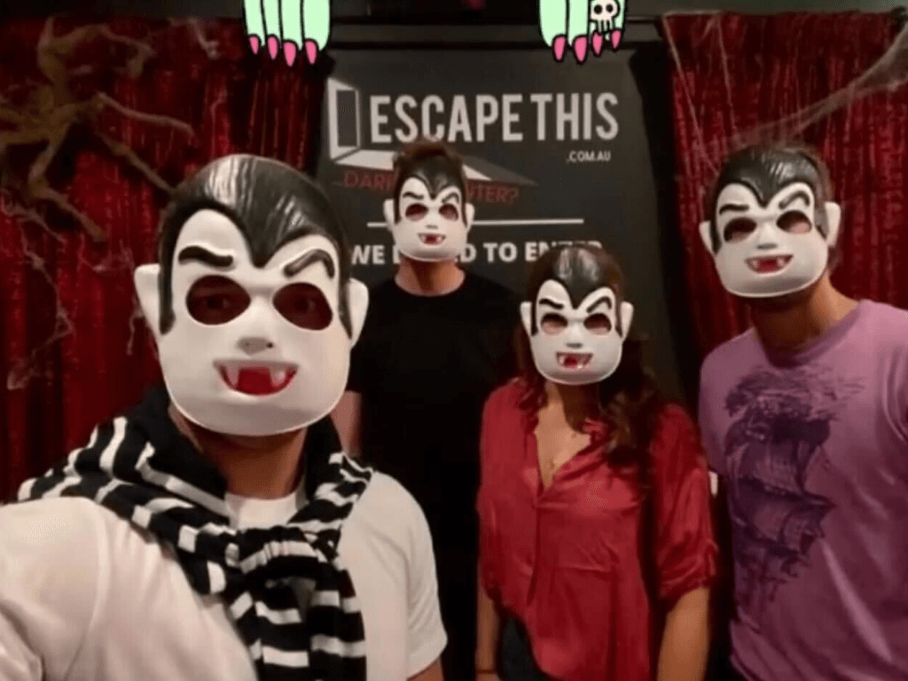 A group of people wearing vampire masks in front of a sign that says escape this