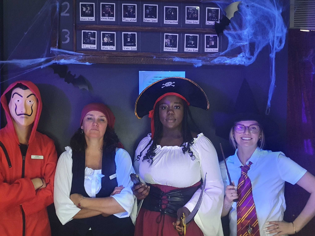 A group of people dressed in halloween costumes are posing for a picture.