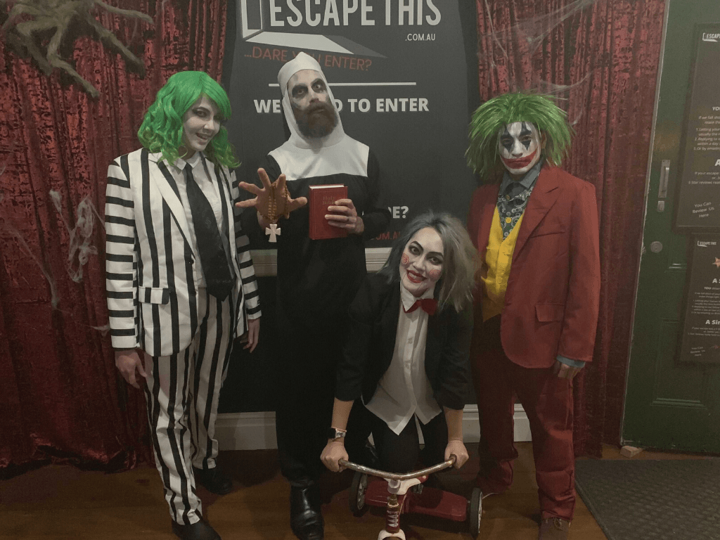 A group of people dressed in halloween costumes are posing for a picture.