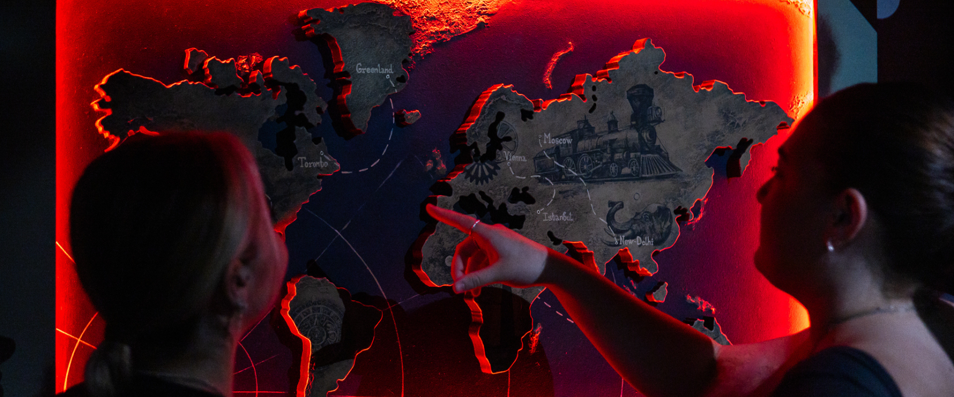 A group of escape room players pointing at a map