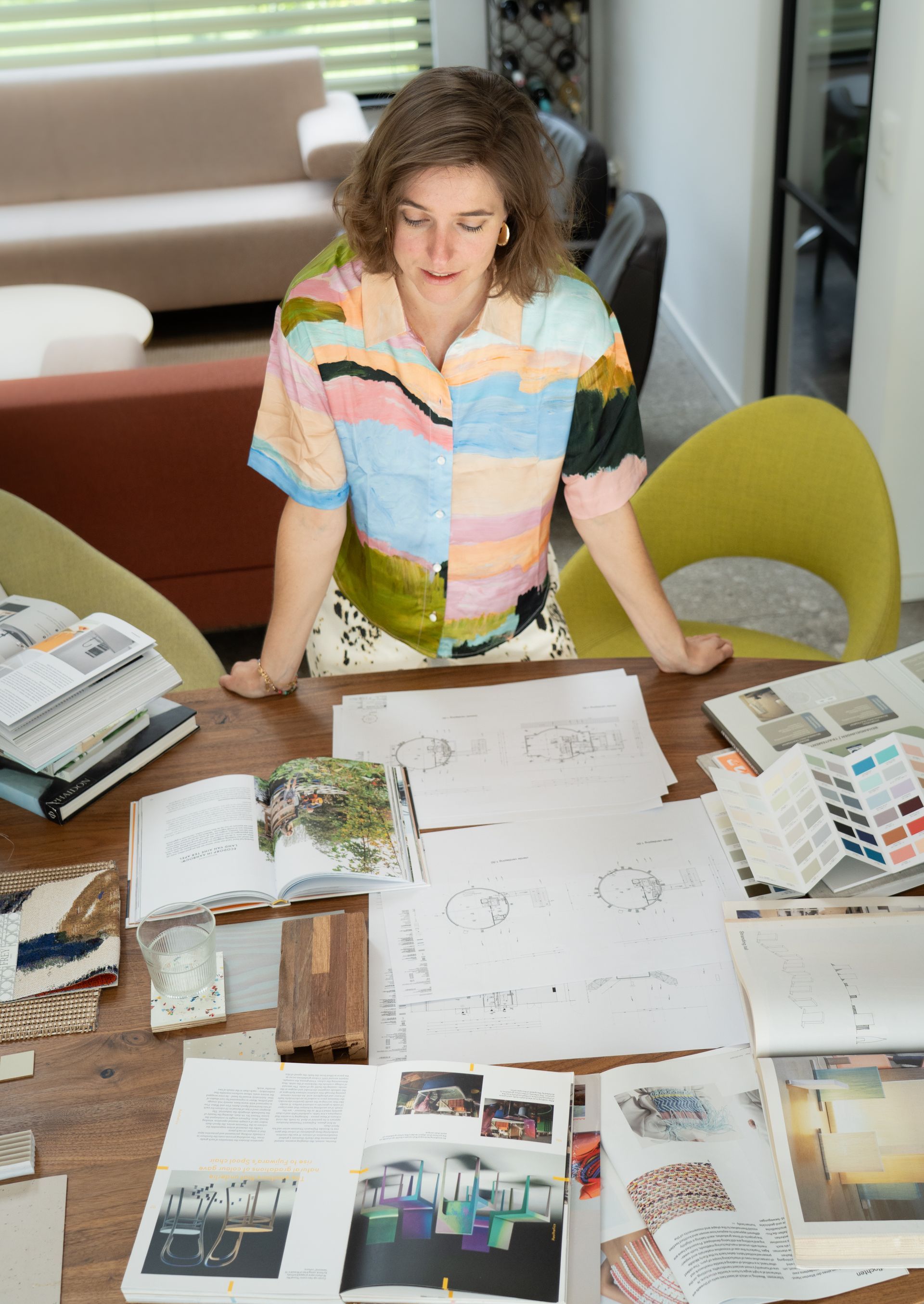Isometrisch beeld van een keuken, inclusief keukenkastjes, een eettafel met stoelen en een boogvormig raam met uitzicht.