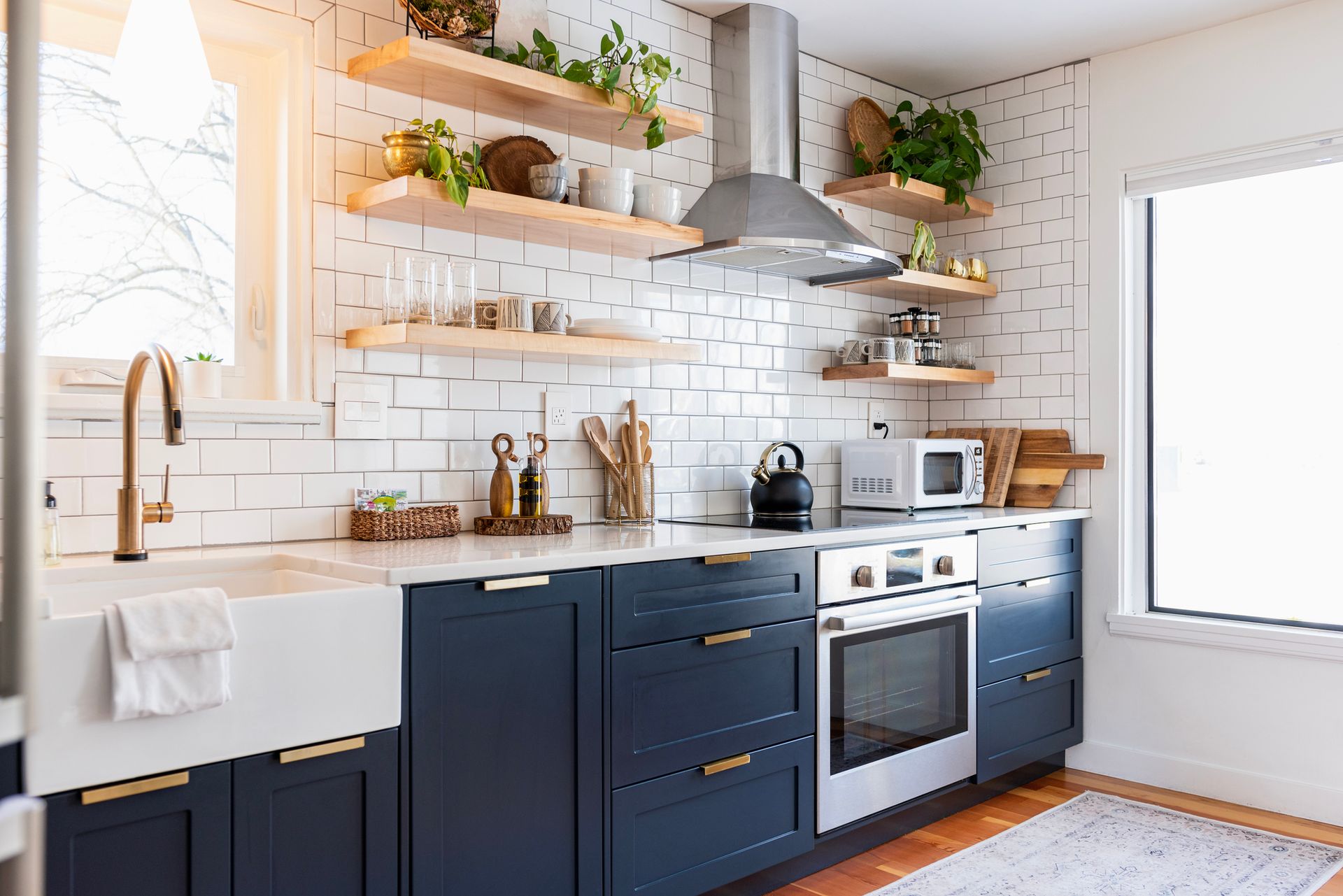 Kitchen remodel supplies in Tacoma, WA with navy cabinets, shelves, and sink from Water Concepts Kit