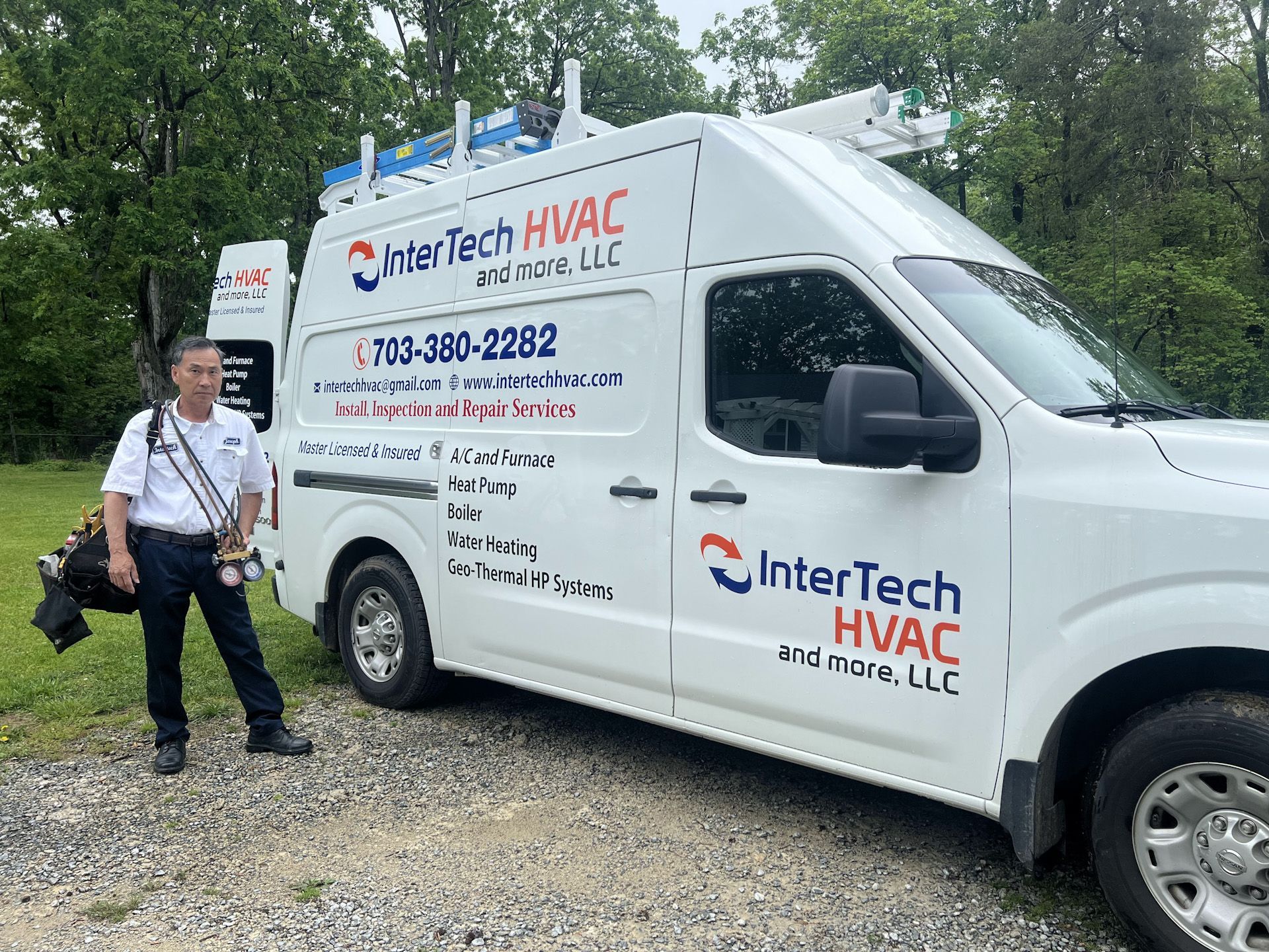 A man is standing next to a white intertech hvac van.