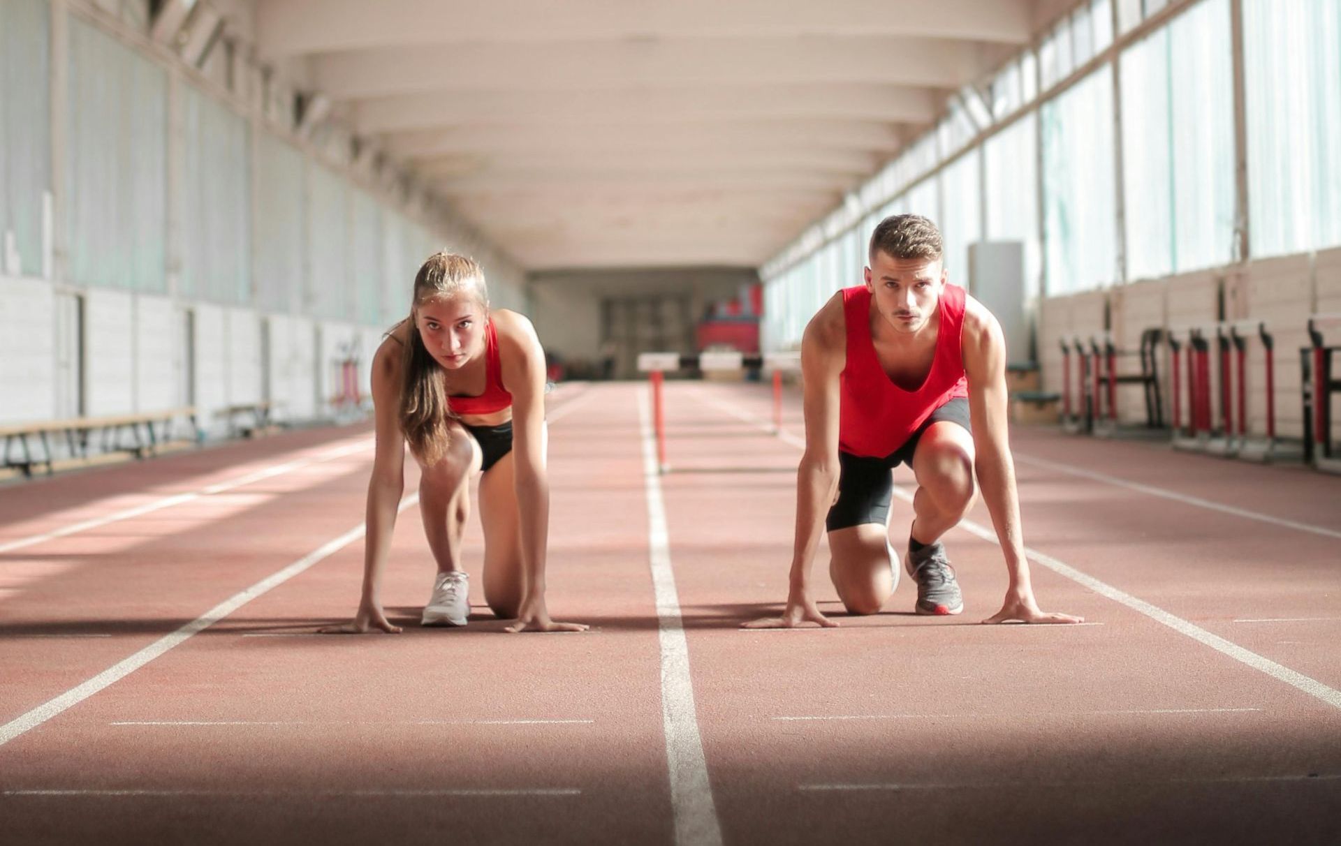 A man and a woman are talking to each other in a gym.