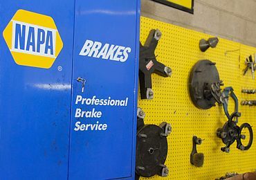 NAPA Brakes professional brake service sign on blue and yellow automotive shop equipment panel | Sunshine Service Automotive Specialists