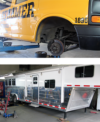 Bus tire removed for repair beside a silver utility trailer in a garage. | Sunshine Service Automotive Specialists