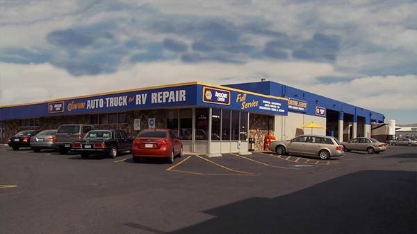 Auto repair shop exterior with parked cars under a cloudy sky | Sunshine Service Automotive Specialists