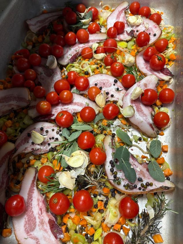Vassoio di pesce crudo guarnito con pomodorini, cipolla, limone, erbe aromatiche e spezie.