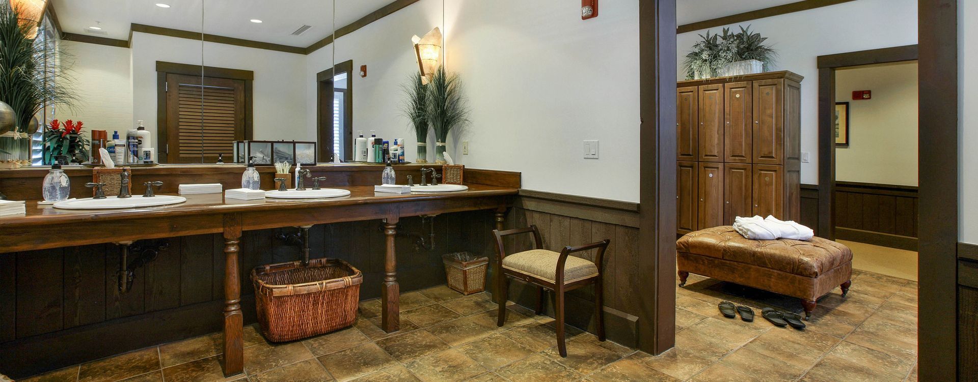 Luxury bathroom with double vanity, mirror, and freestanding tub in a warm, tan-toned setting