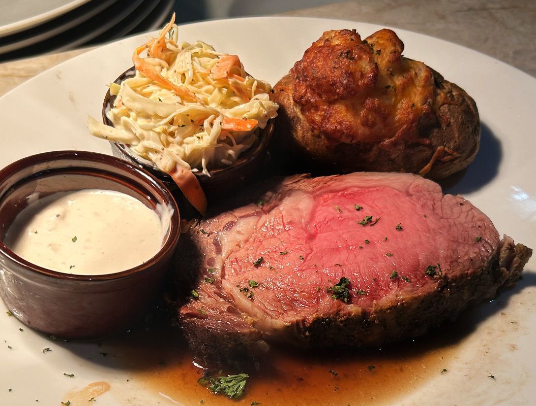 Plated steak with creamy sauce and coleslaw on a white plate