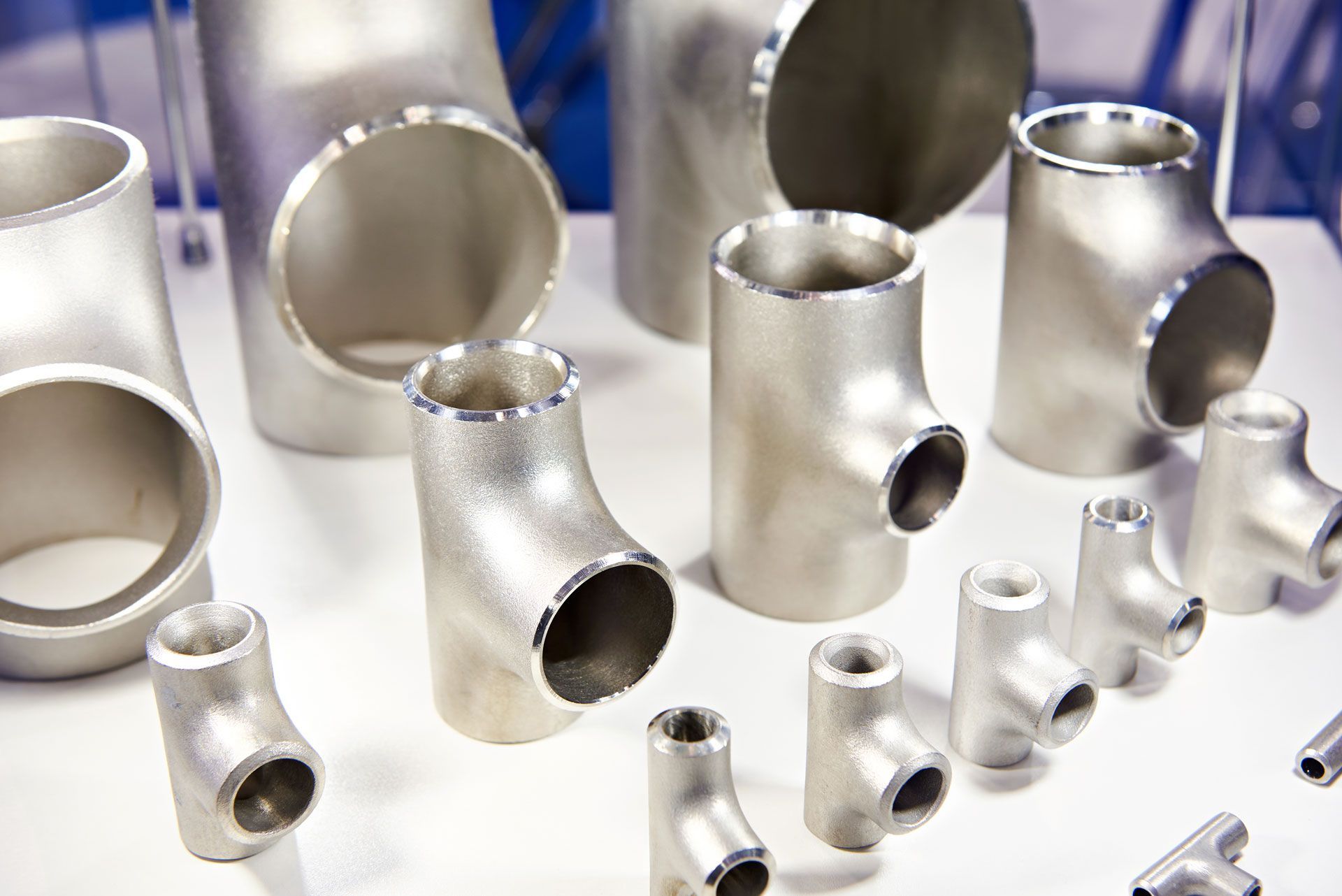 A table topped with a variety of stainless steel pipe fittings.