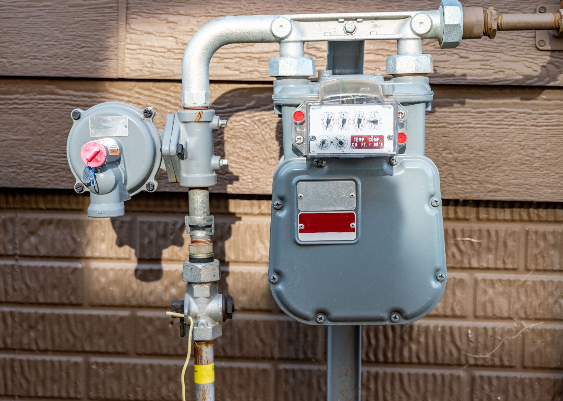 A gas meter is attached to the side of a building.