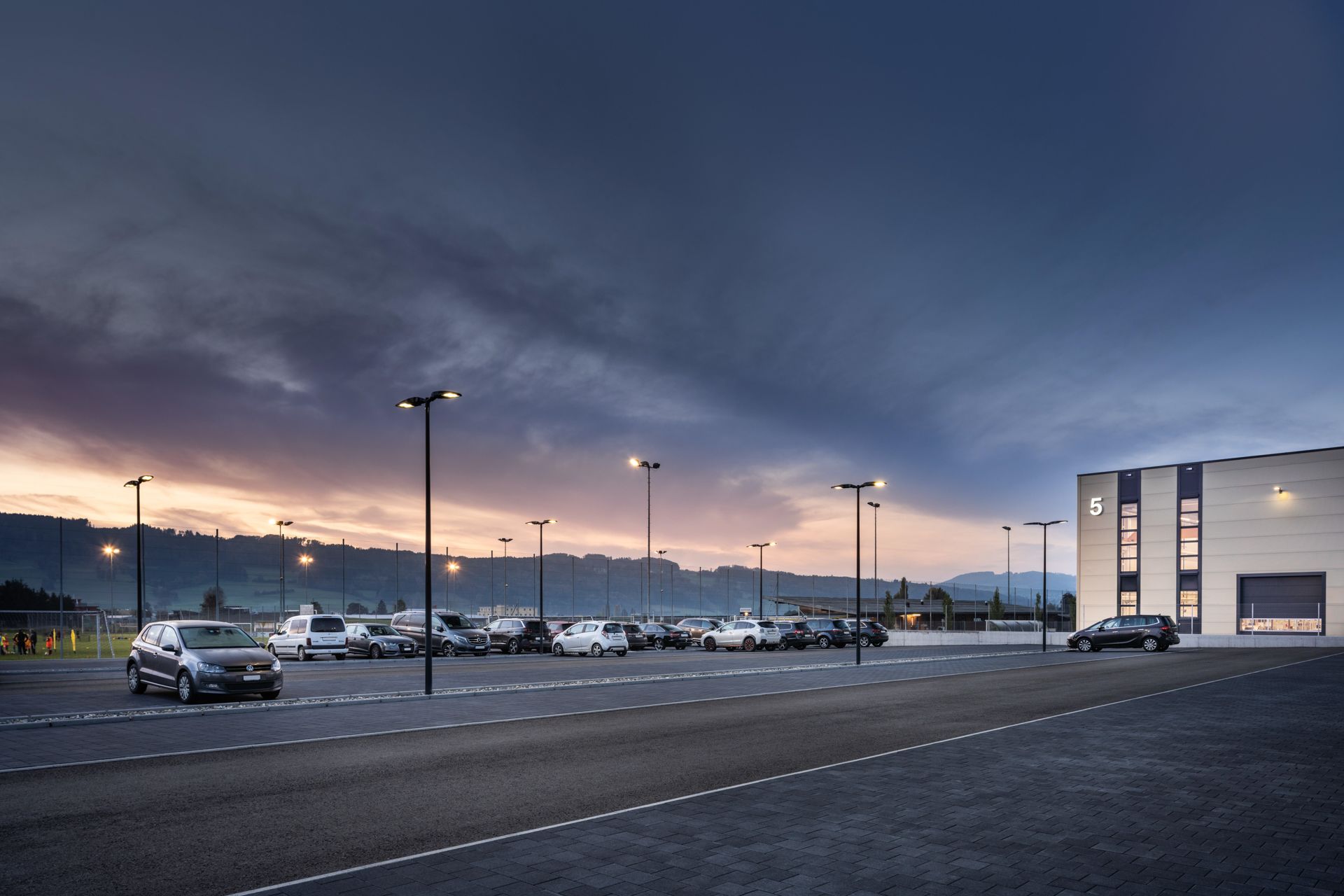 Ein Parkplatz mit vor einem Gebäude geparkten Autos