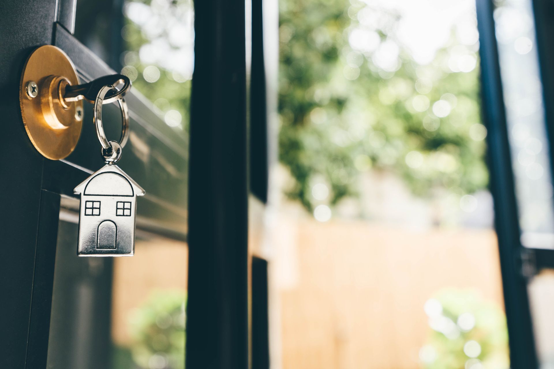 House keys hang from the front door of a new home, representing safety,