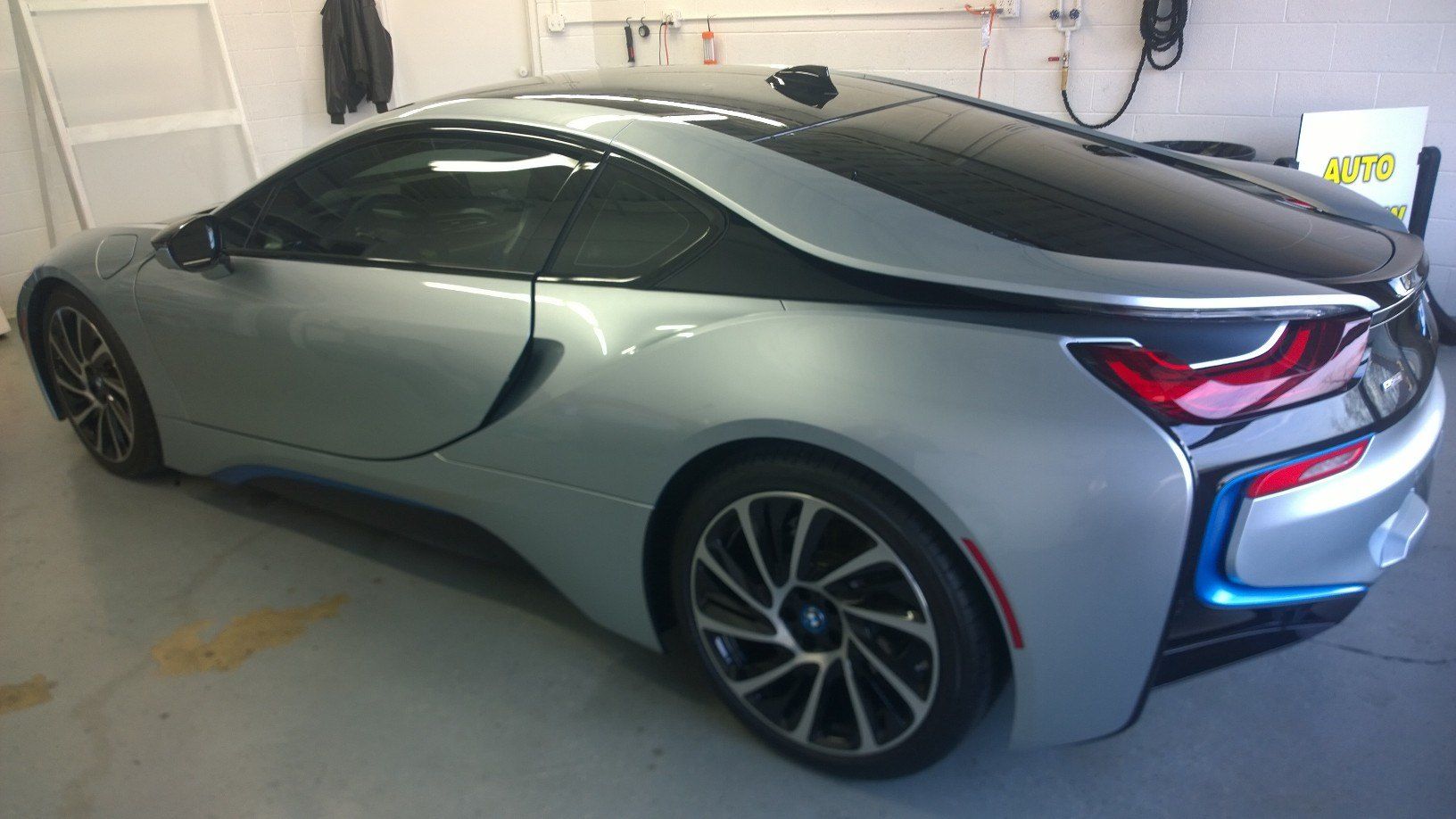 A silver bmw i8 is parked in a garage