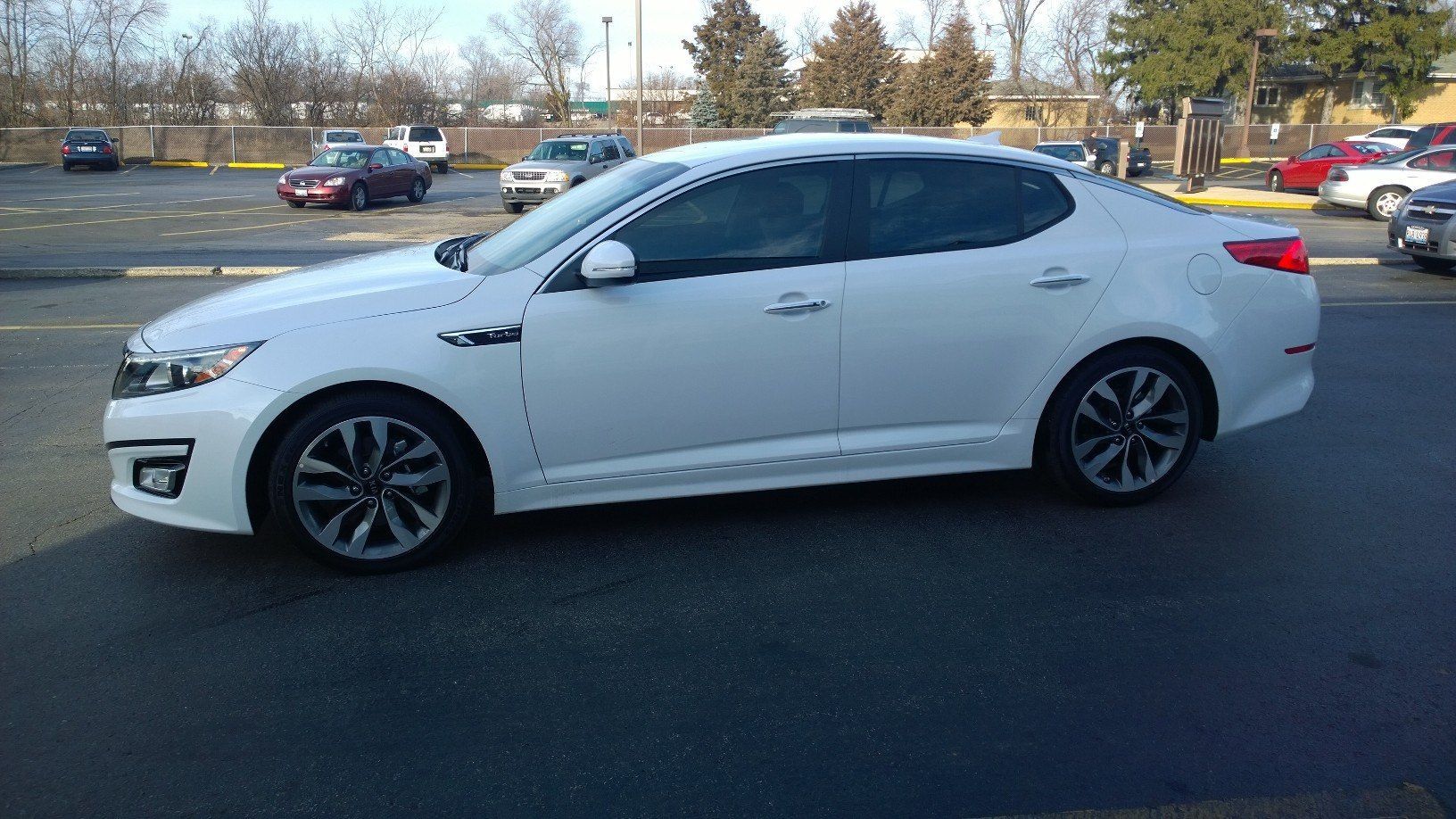 A white car is parked in a parking lot.