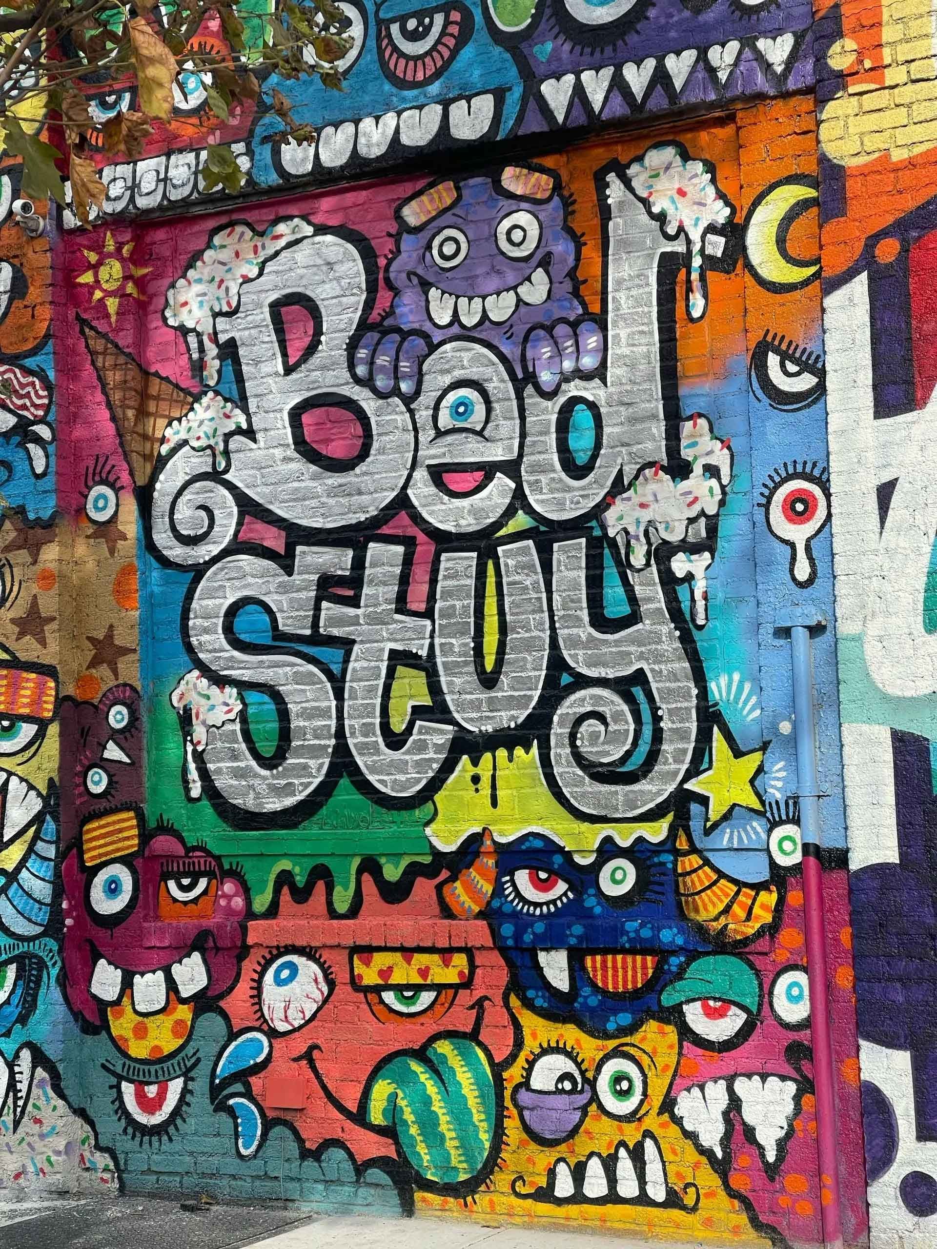 Vibrant, multicolored graffiti mural on a brick wall featuring the words