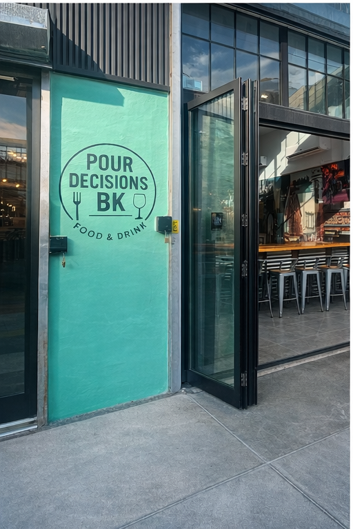 The turquoise wall of a restaurant entrance displays a circular logo that reads
