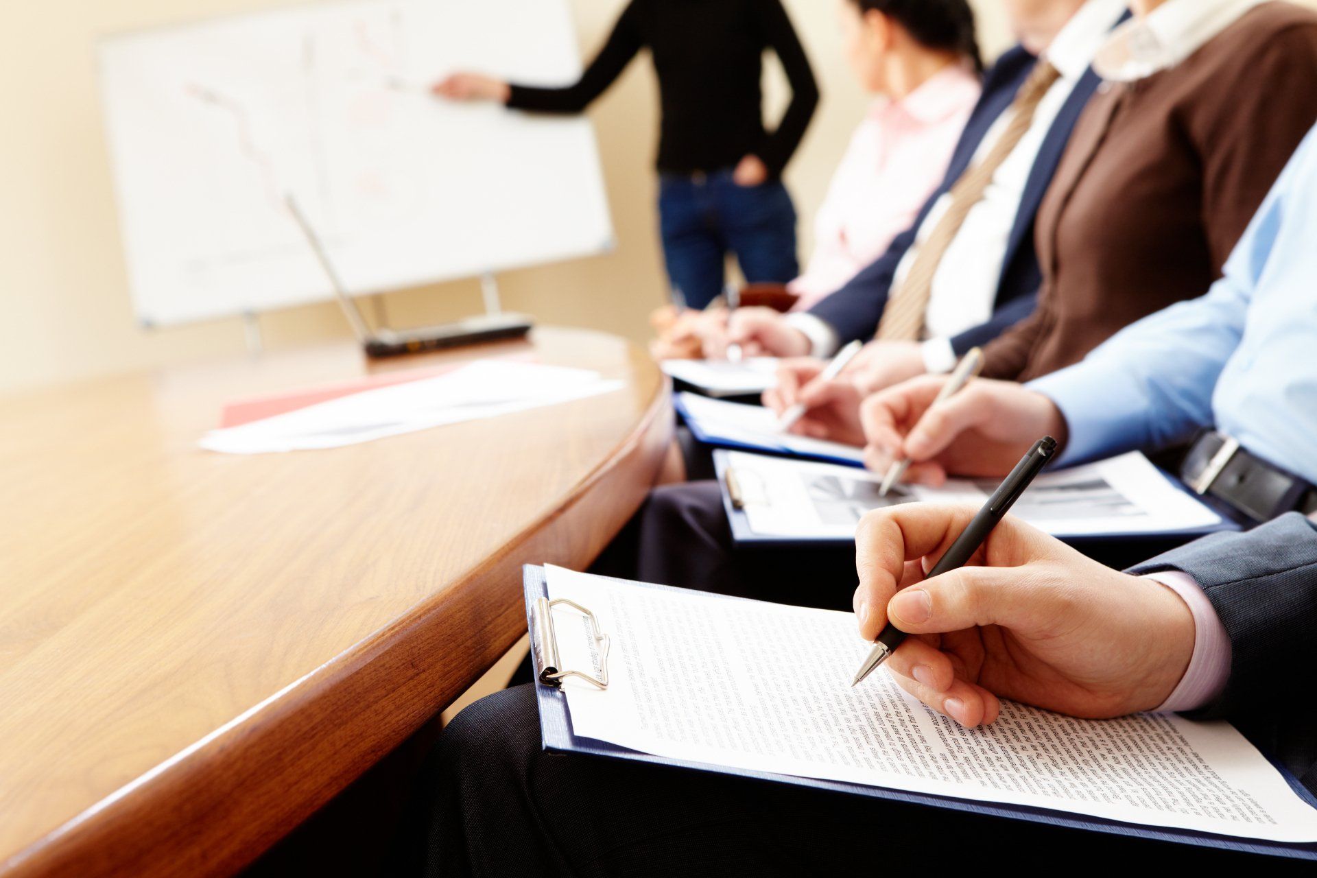 A group of people are sitting at a table taking notes