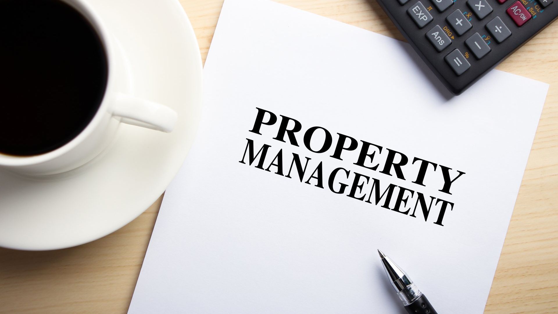 A cup of coffee is on a saucer next to a piece of paper that says property management.