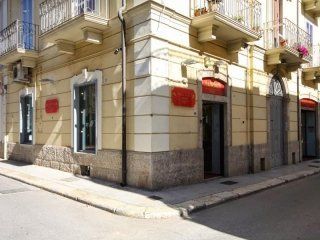 Un edificio con un cartello rosso su un lato si trova all'angolo di una strada.