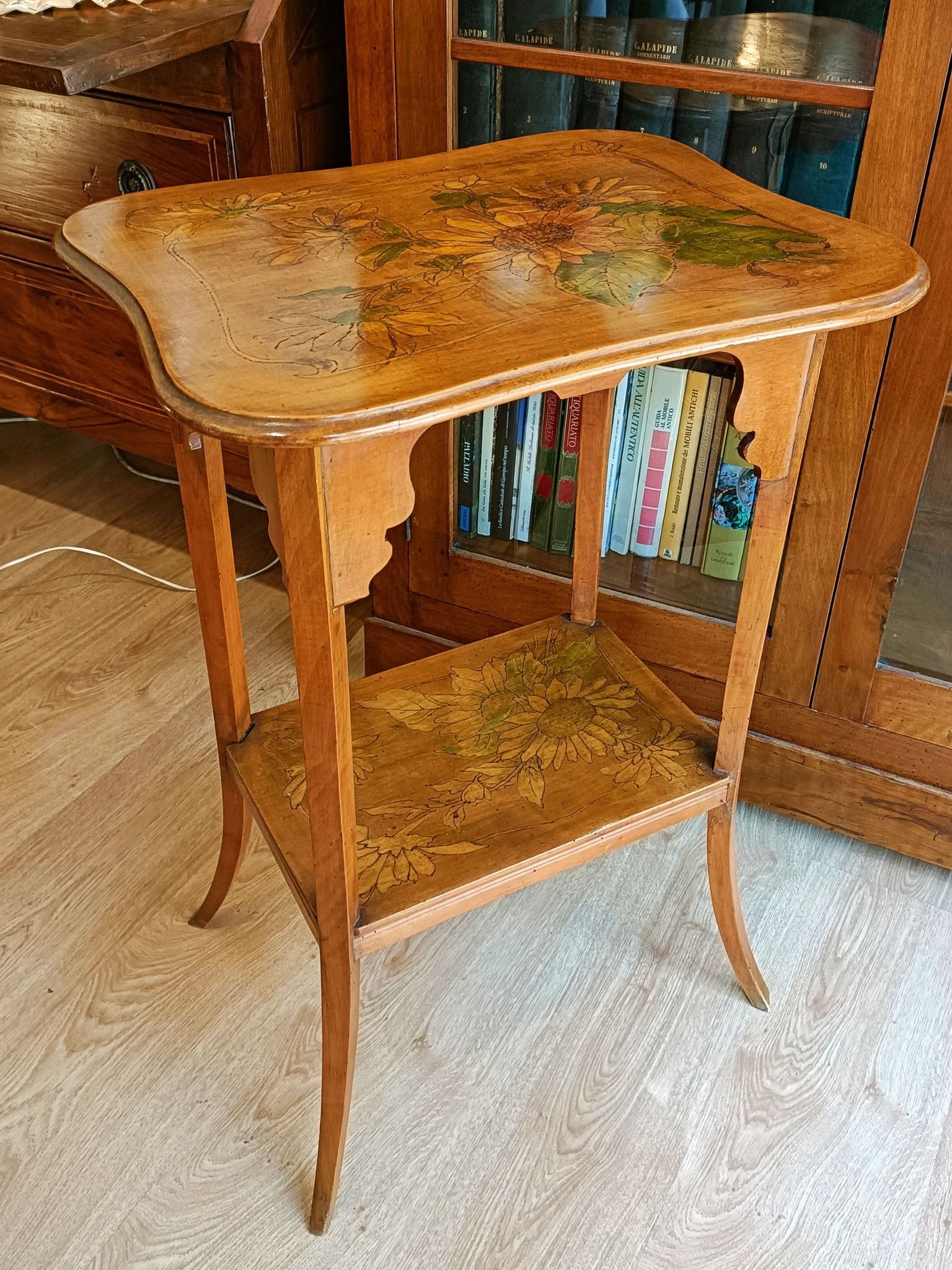 Un tavolino di legno è appoggiato davanti a una libreria.
