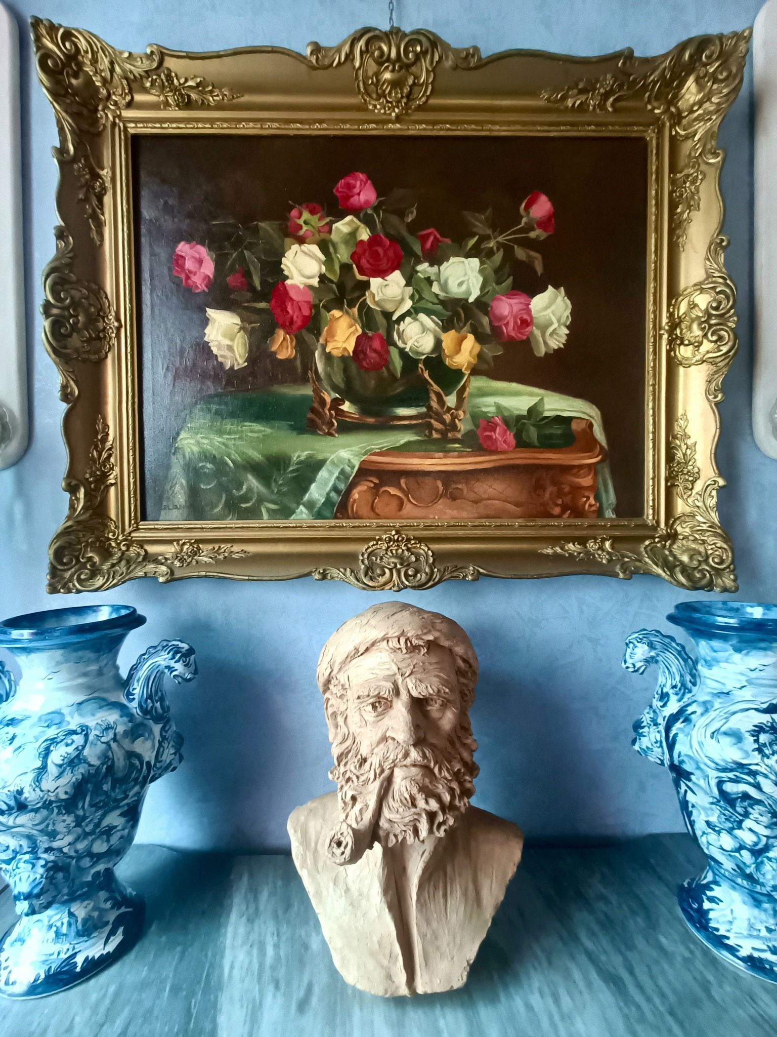 Un dipinto di fiori in un vaso è appeso a una parete.