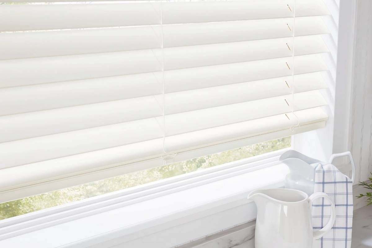 Cream-colored Hunter Douglas Parkland® Wood Blinds on a kitchen window with two pitchers on the counter at Advantage Blinds near Prosper, Texas (TX)