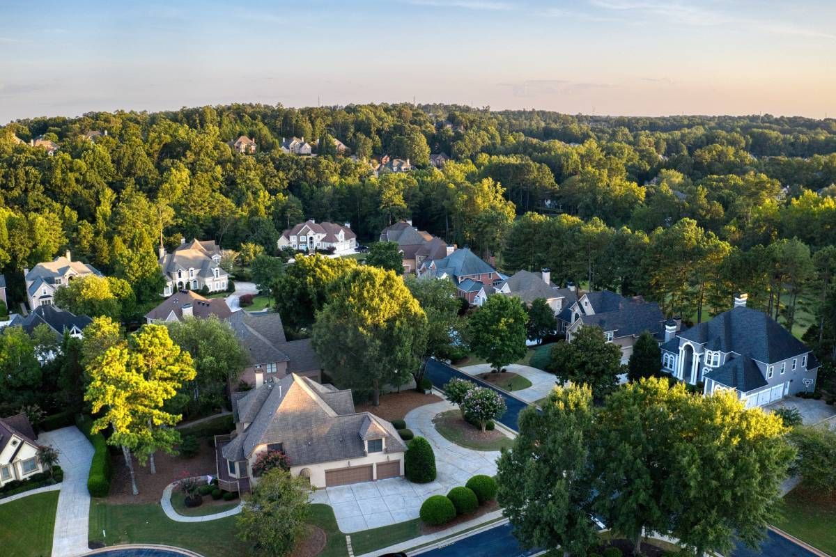 Ariel view of a suburban Texas neighborhood filled with homes, lush trees, and a beautiful sunset near Prosper, TX