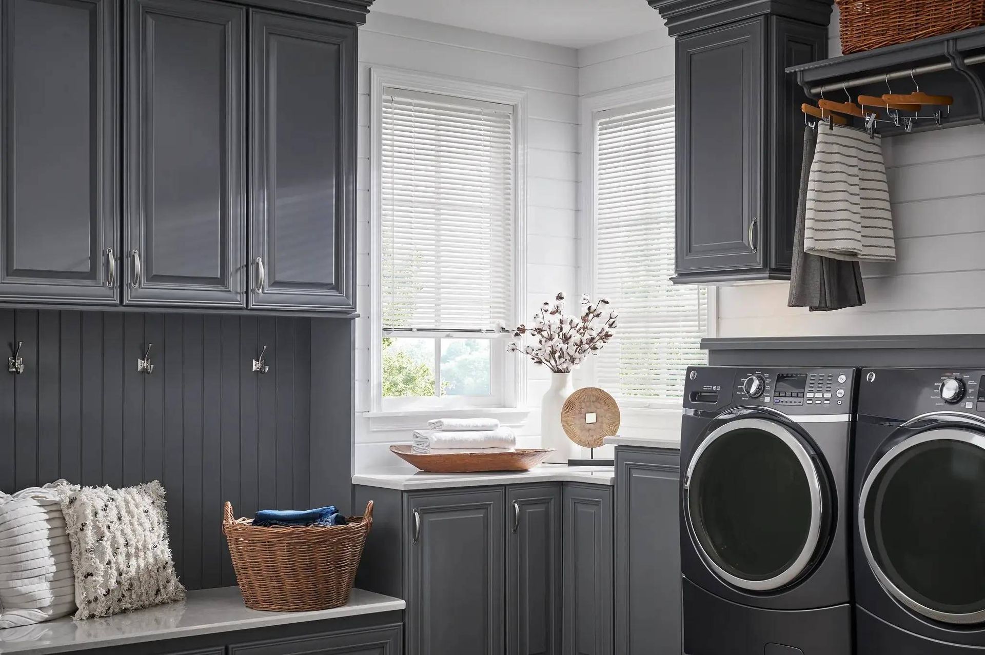 Durable and water-resistant Alta Aluminum Blinds on two windows in a well-organized laundry room