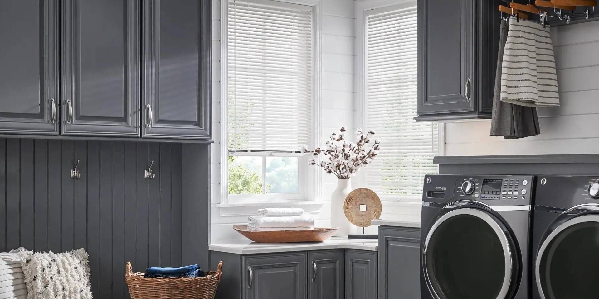 Durable and water-resistant Alta Aluminum Blinds on two windows in a well-organized laundry room