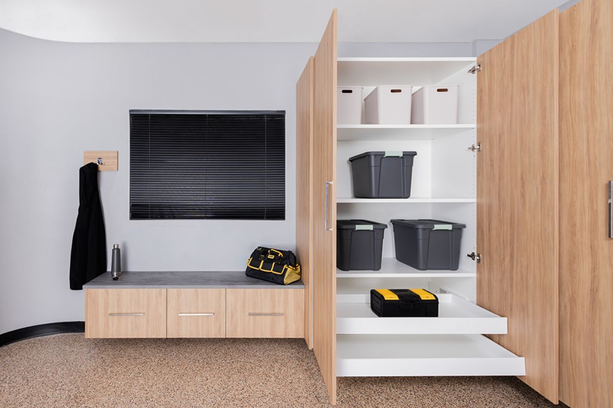 A garage with wooden cabinets and a flat screen tv.