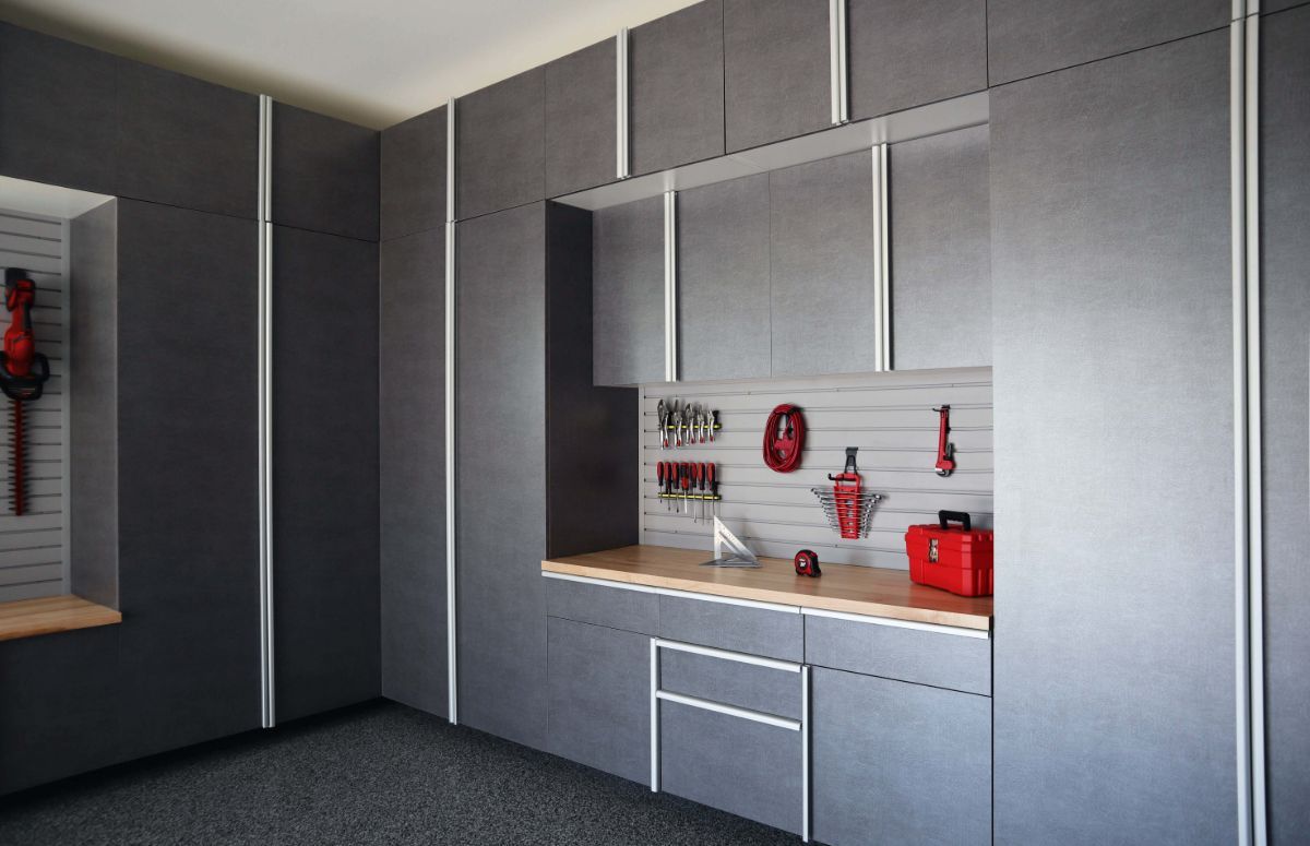 A garage with gray cabinets and a wooden counter top.