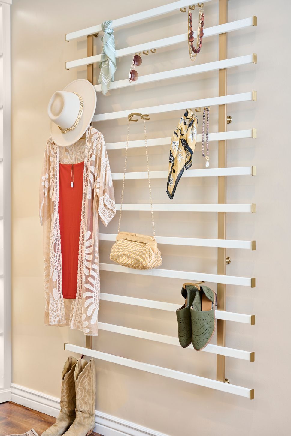 A clothes rack with clothes hanging on it and a hat hanging on it.