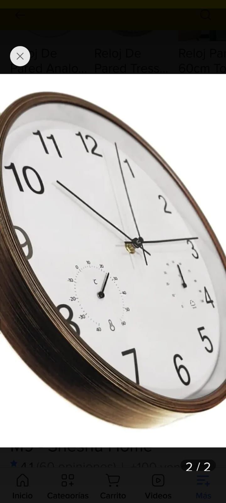 Reloj de pared redondo de madera sobre una repisa, que marca aproximadamente las 10:10 sobre una pared blanca.
