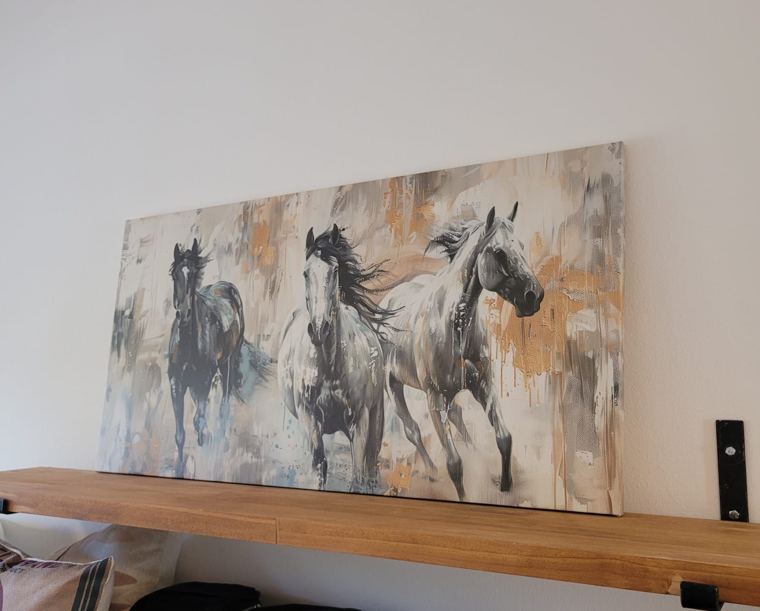 Pintura abstracta de un caballo sobre un estante con tonos grises, negros y naranjas apagados.