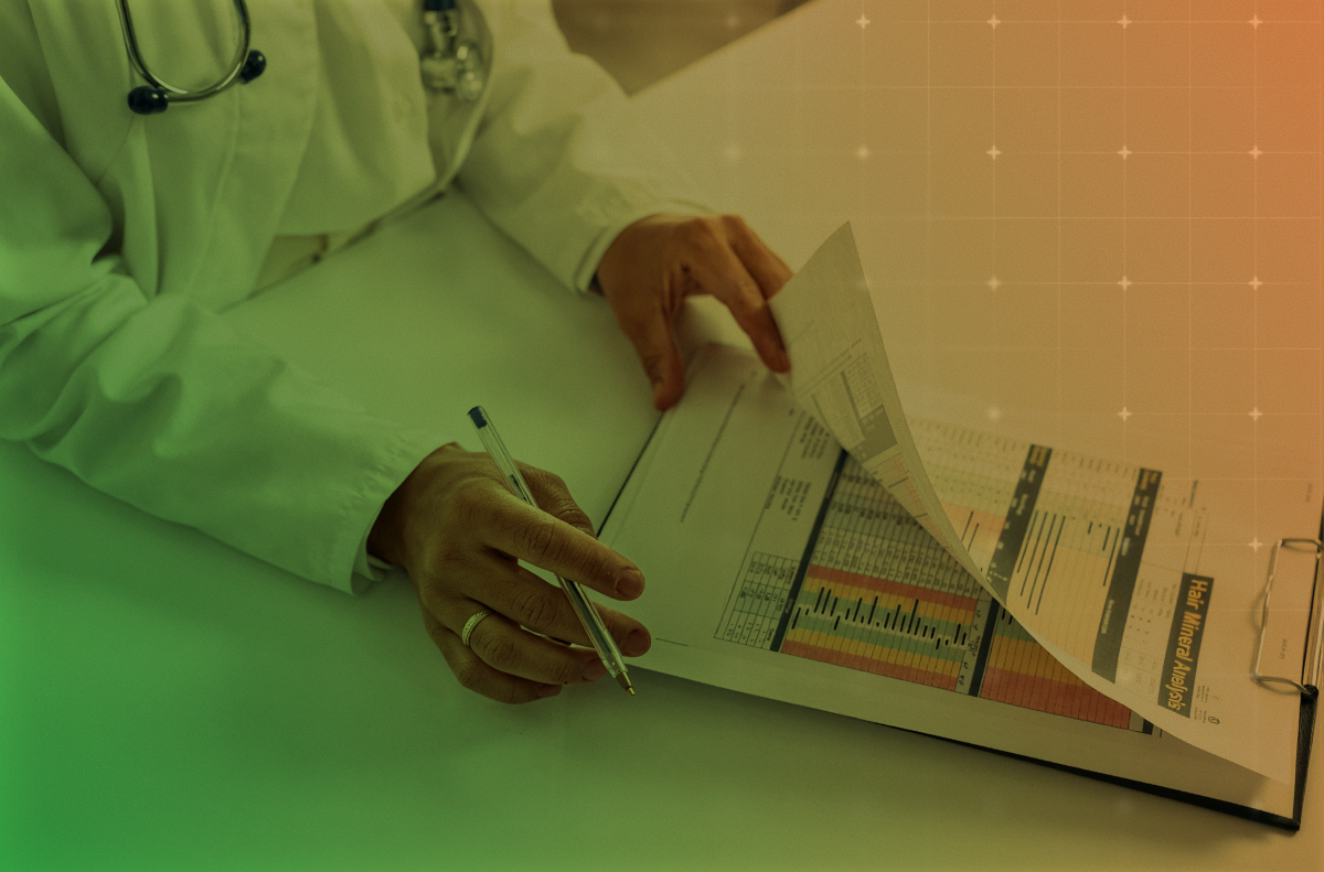 Person in white coat reviewing charts and documents on a desk, with green and orange lighting.