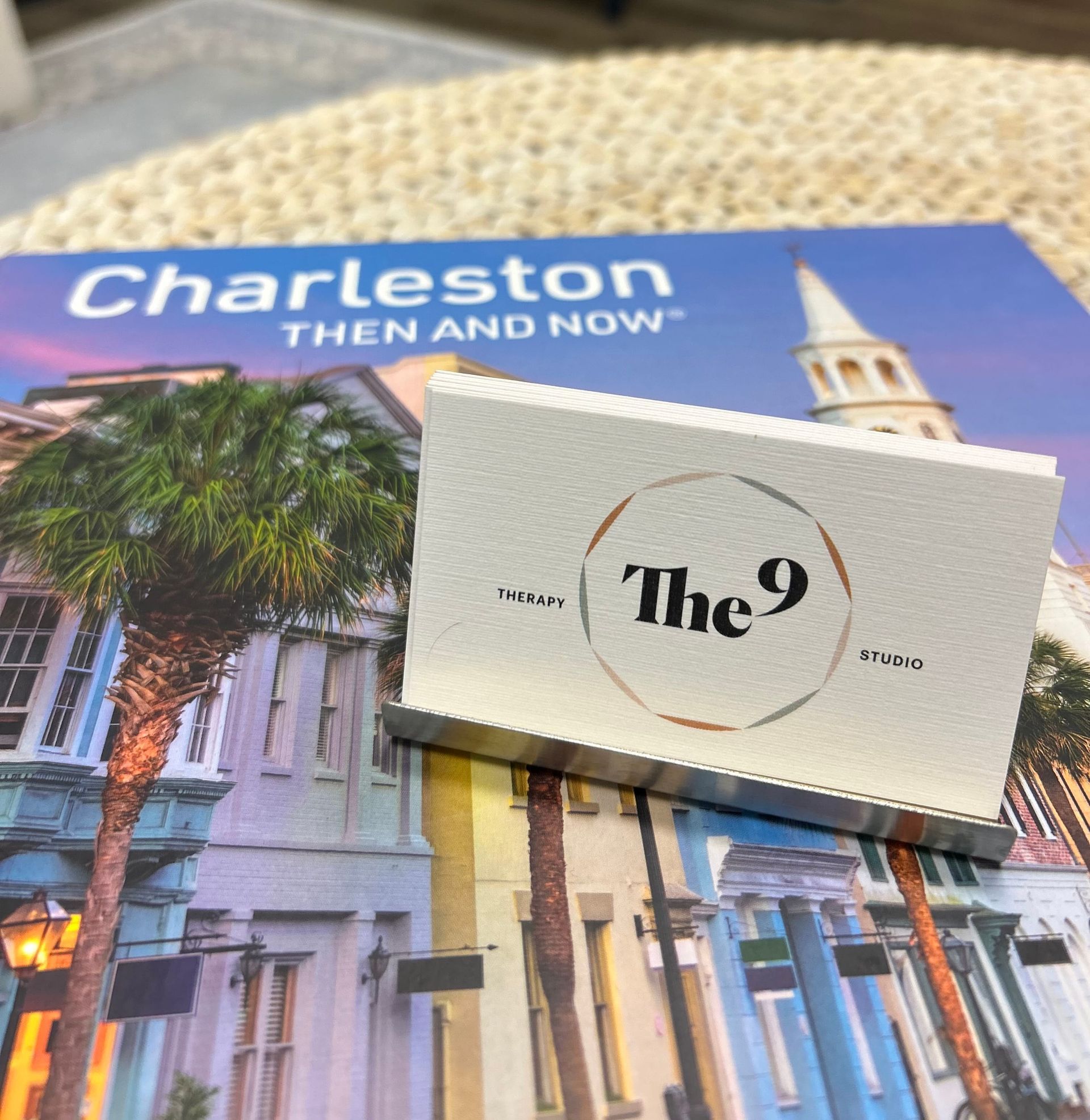 Charleston Then and Now book with a white The 9 card resting on the cover