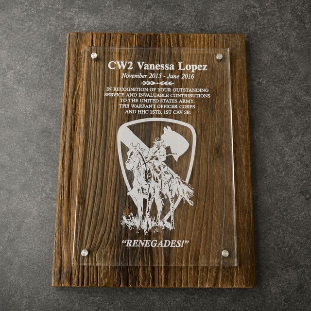 Wooden plaque with engraved text and a white Renegades logo on a gray surface