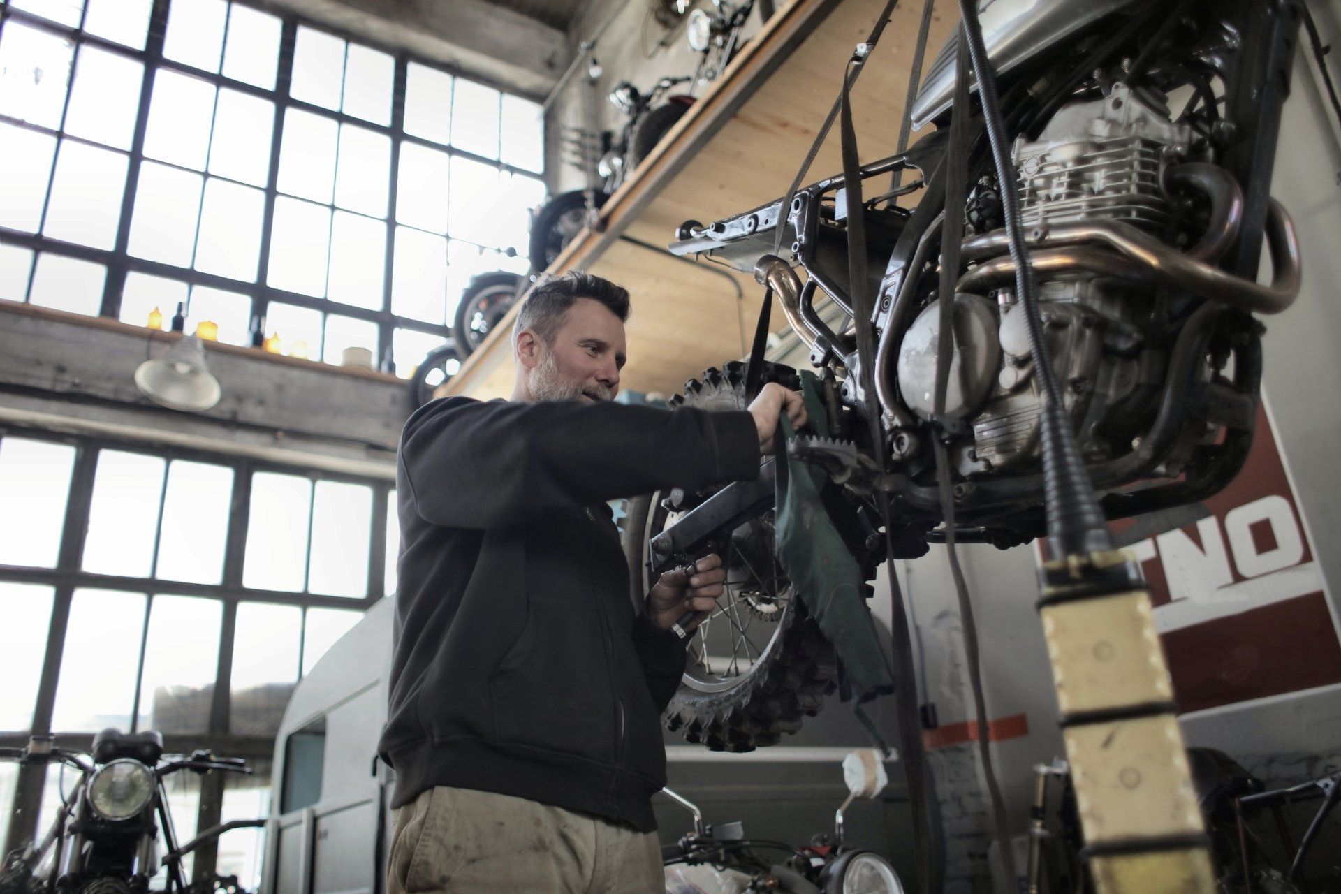 Mechanic working on a large red tractor inside a workshop