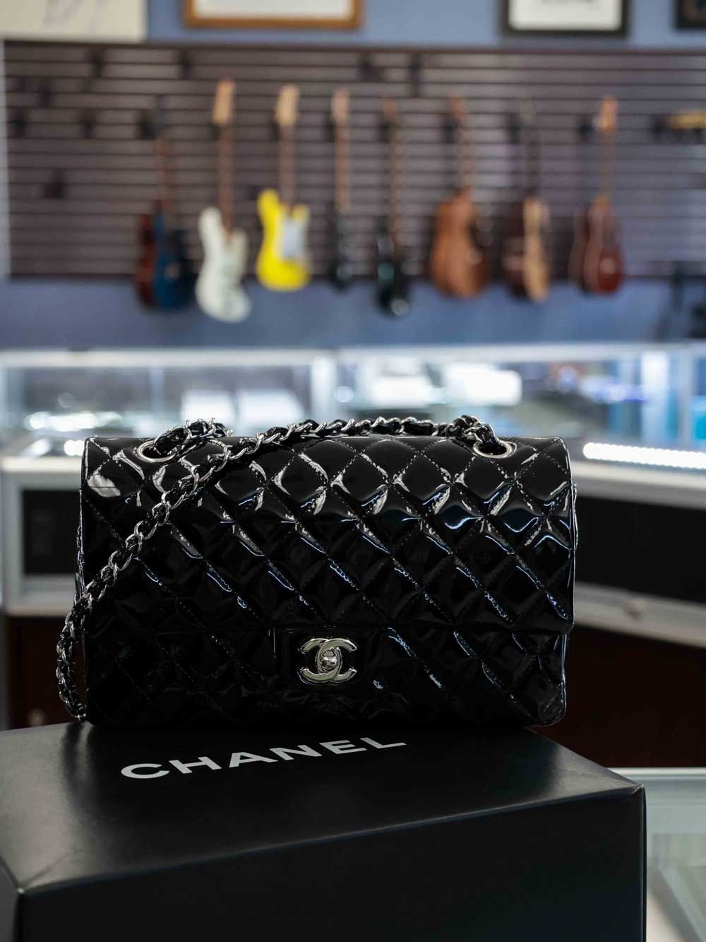 Black quilted Chanel handbag on a Chanel box in a music store display.